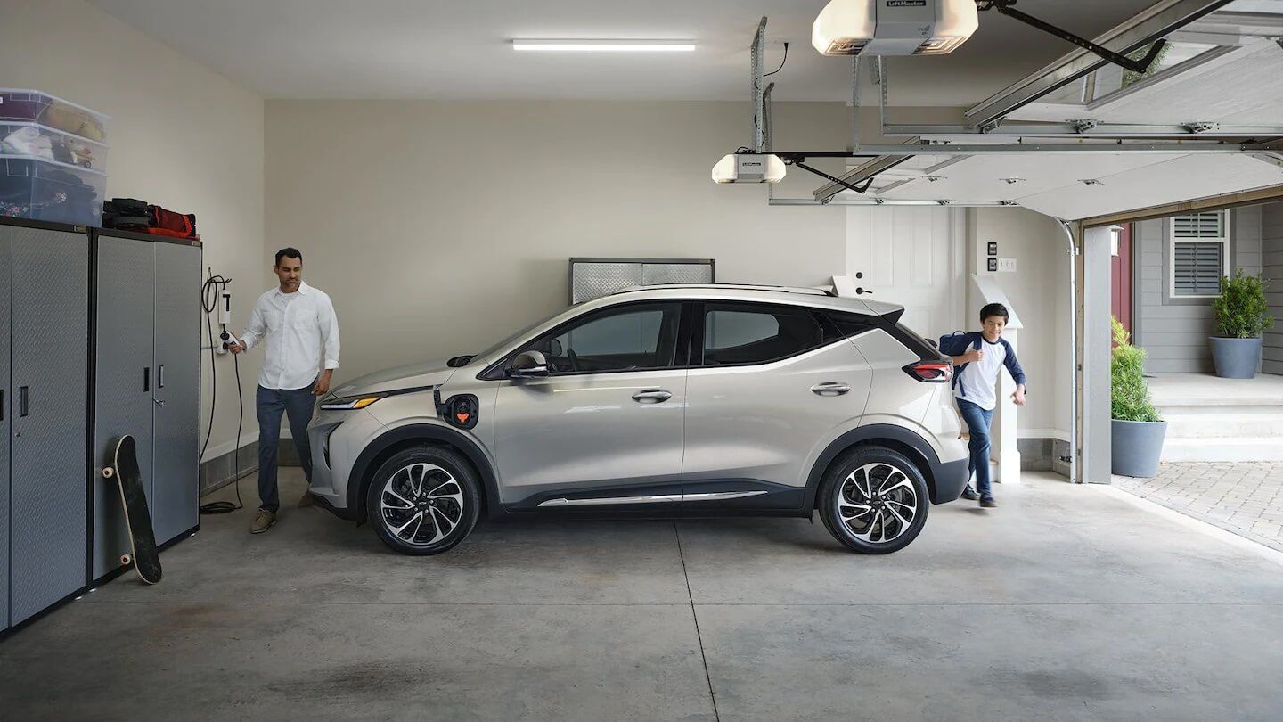 Homme s'apprêtant à charger sa Chevrolet Bolt EV 2022 dans son garage à domicile