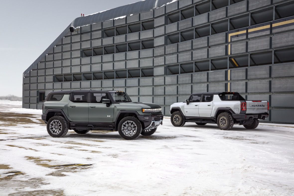 Le VUS GMC Hummer EV garé à la gauche du pickup GMC Hummer EV 2023 pendant la saison d'hiver