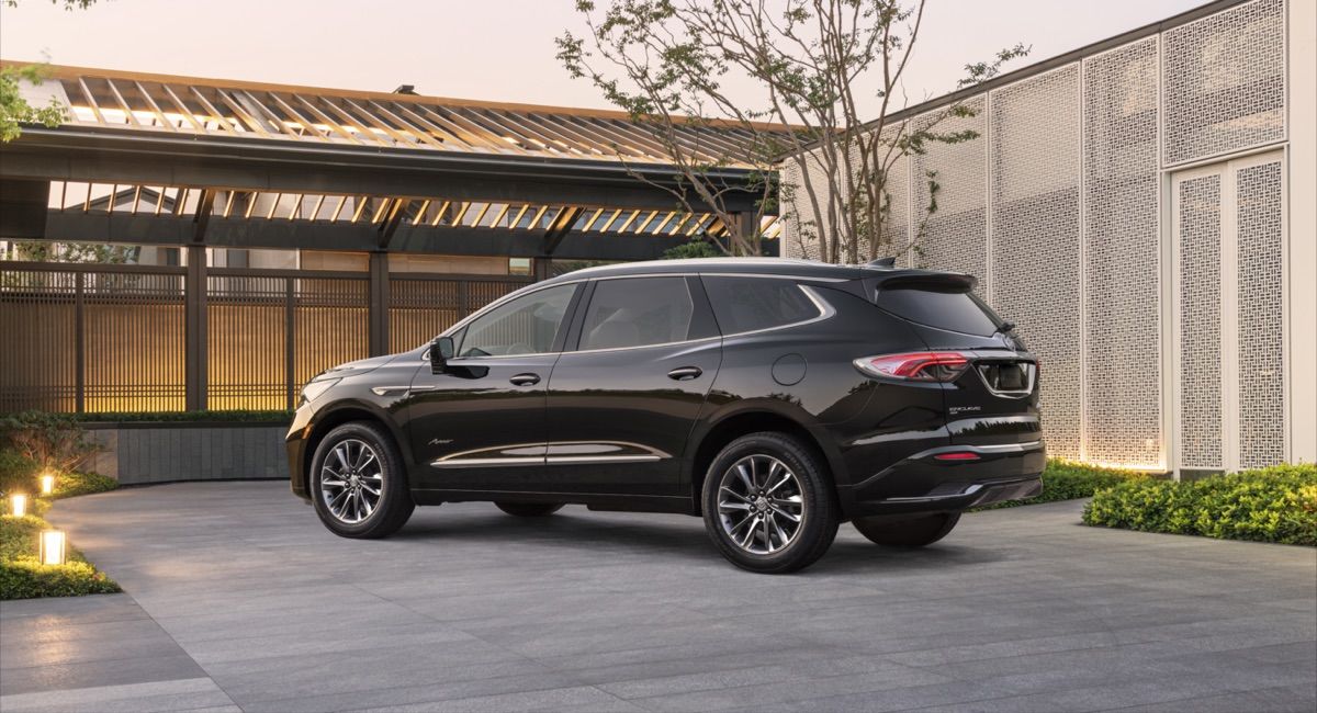 Vue 3/4 latérale du Buick Enclave Avenir 2022 noir garé à l'extérieur devant sa maison