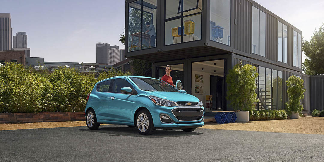 Femme embarquant dans sa nouvelle Chevrolet Spark 2021 garée dans un stationnement