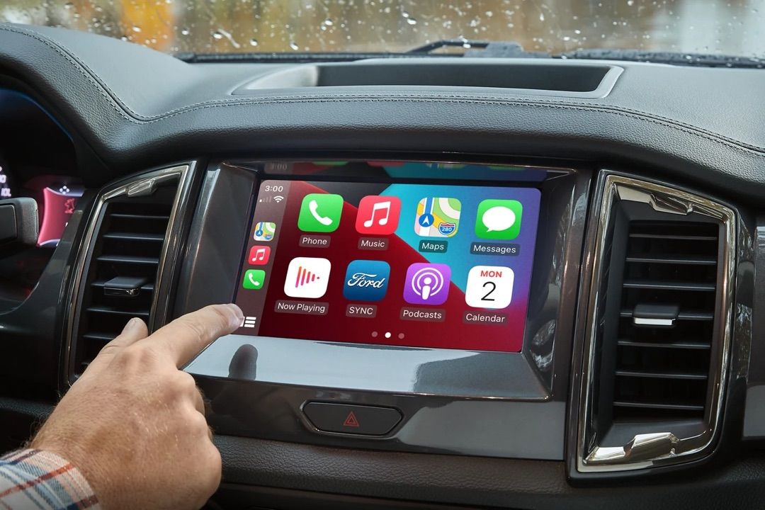 Main au contrôle de l'application Apple CarPlay.