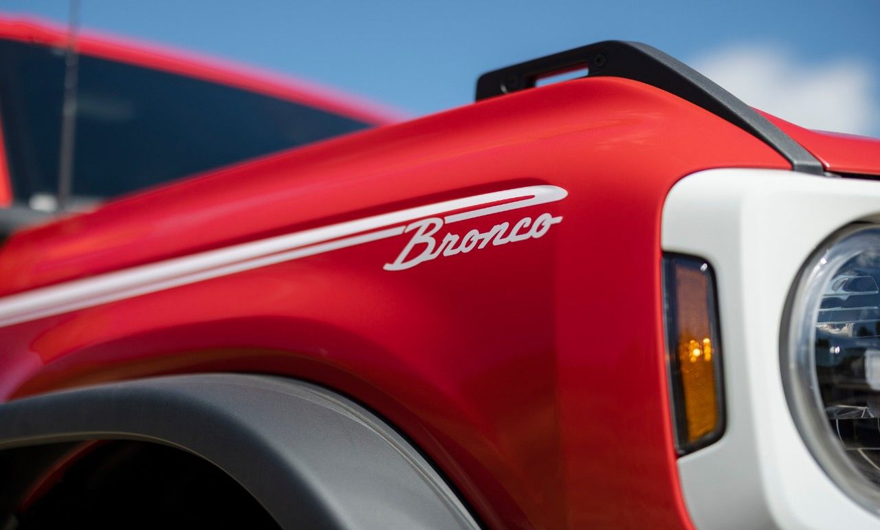 Gros plan des lettres Bronco sur la carrosserie rouge du Ford Bronco Heritage.