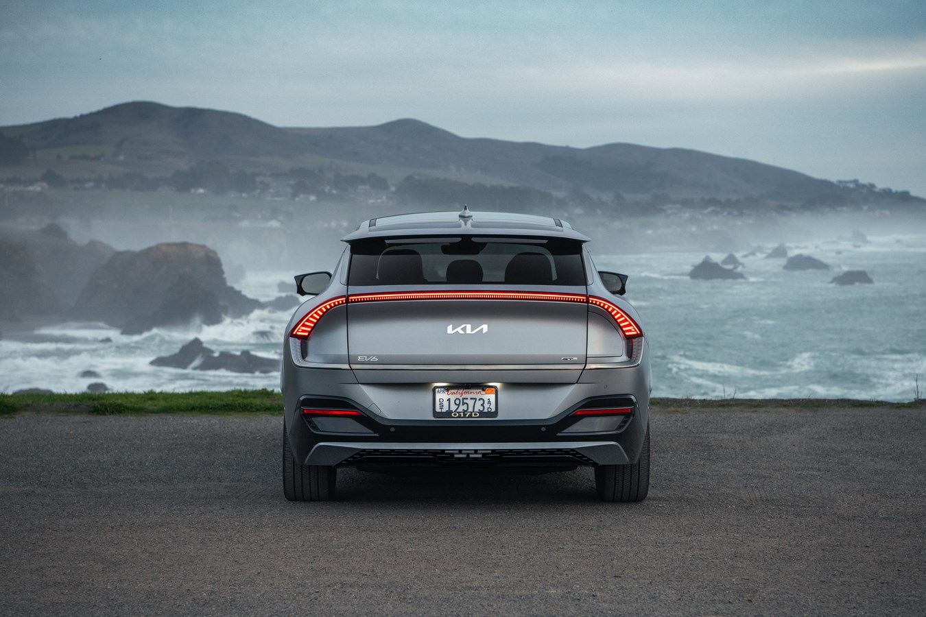 rear view of a 2024 Kia EV6 by the sea on a cloudy day