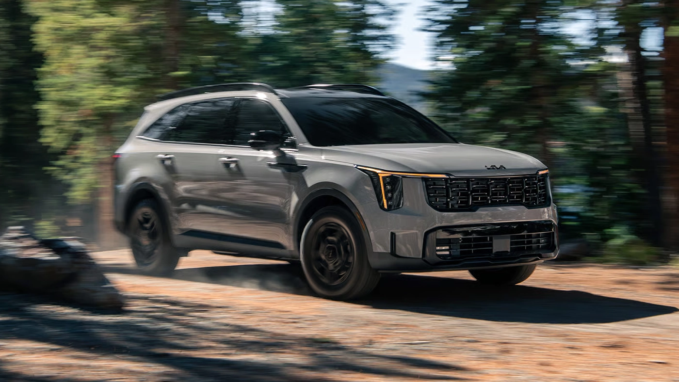 Vue 3/4 avant et lat&eacute;rale du Kia Sorento 2026 sur un chemin en for&ecirc;t en pleine puissance