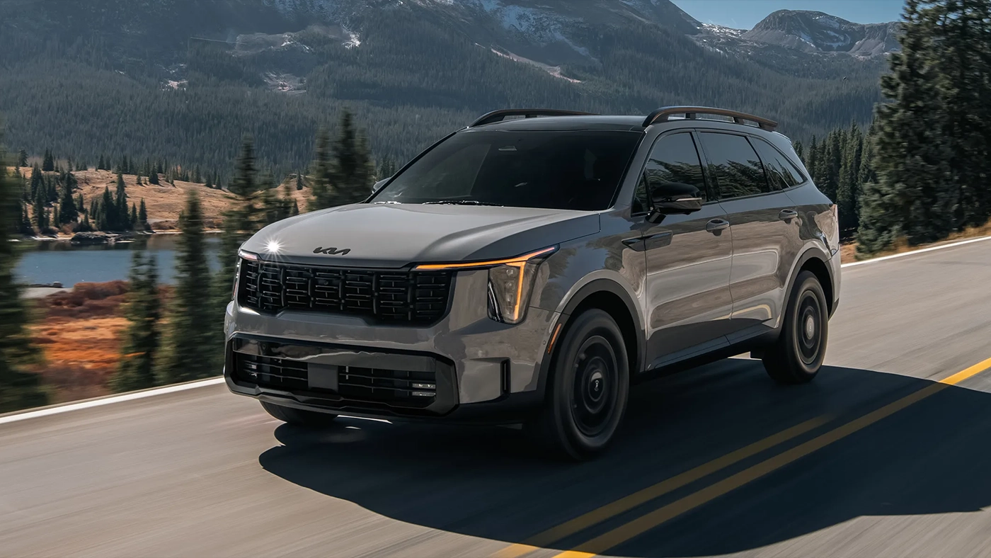 Vue 3/4 avant et lat&eacute;rale du Kia Sorento 2026 sur route avec vue de montagne