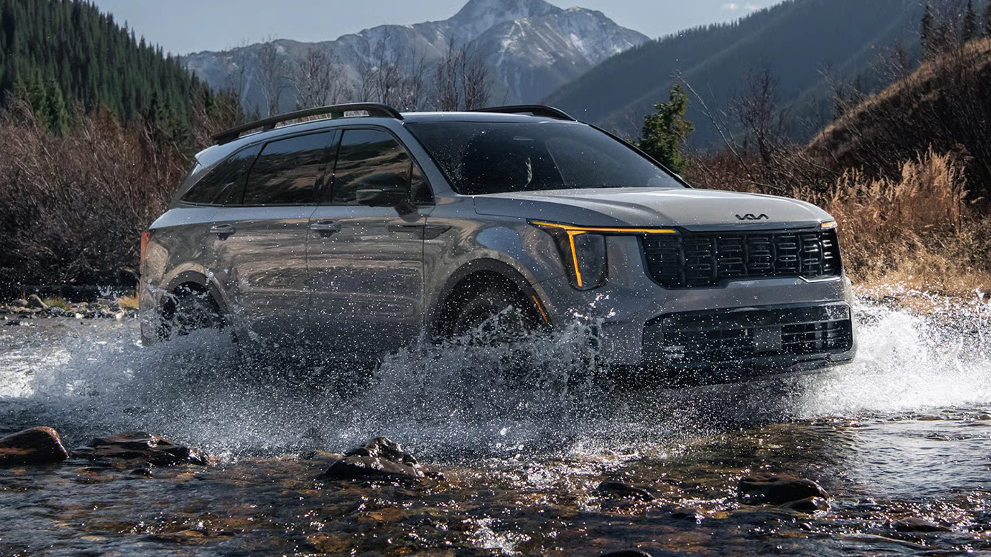 Vue 3/4 avant et lat&eacute;rale du Kia Sorento 2026 traversant une marre d'eau