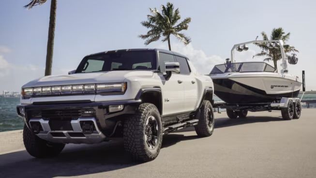 The Hummer EV 2025 truck towing a boat.