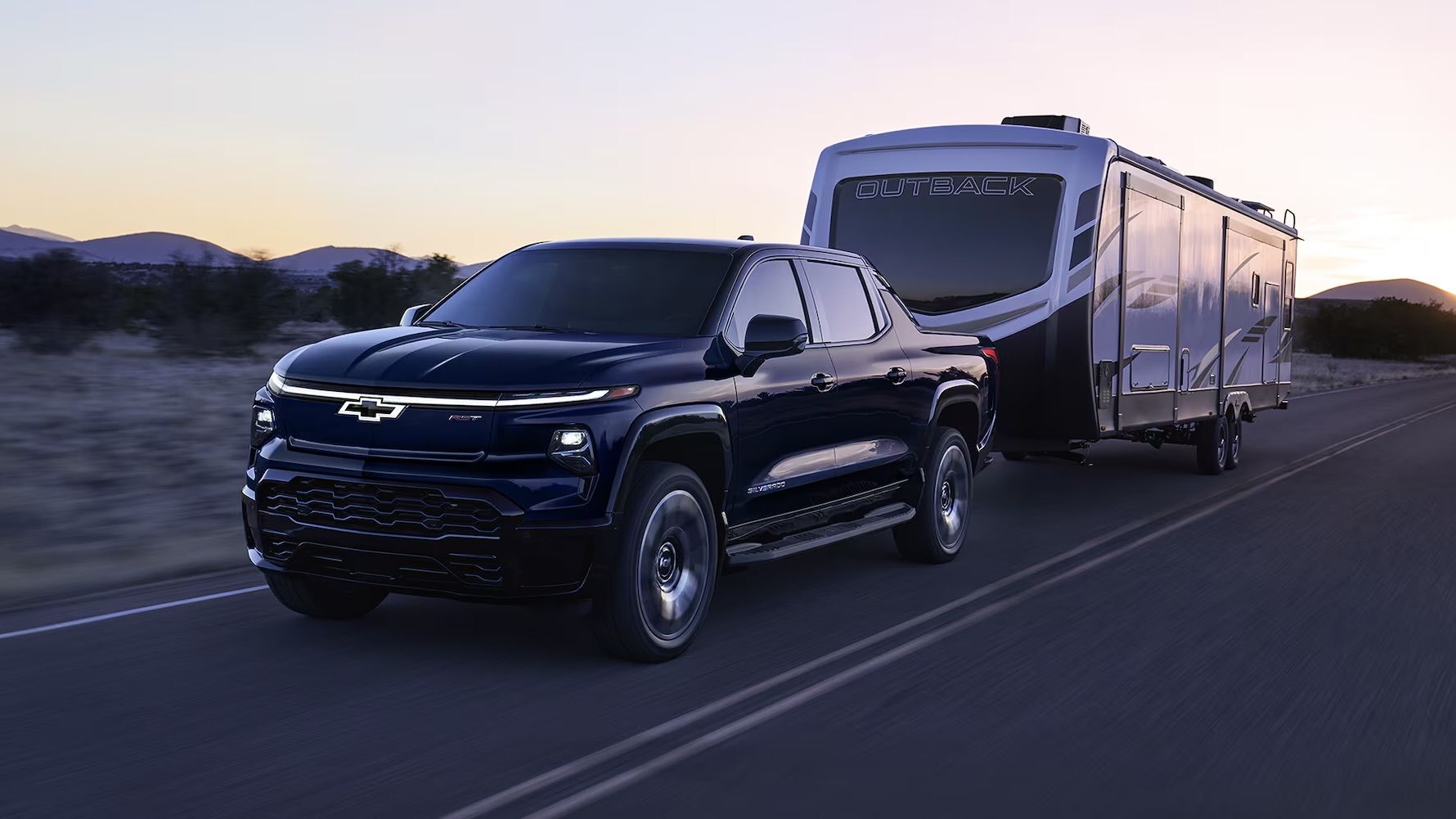 Le Chevrolet Silverado EV 2024 qui tire une roulotte sur la route.