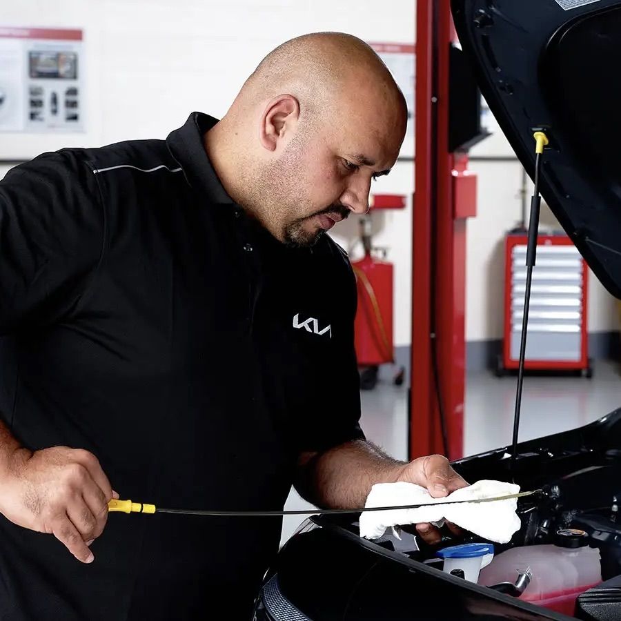 A mechanic checking the oil in an engine.