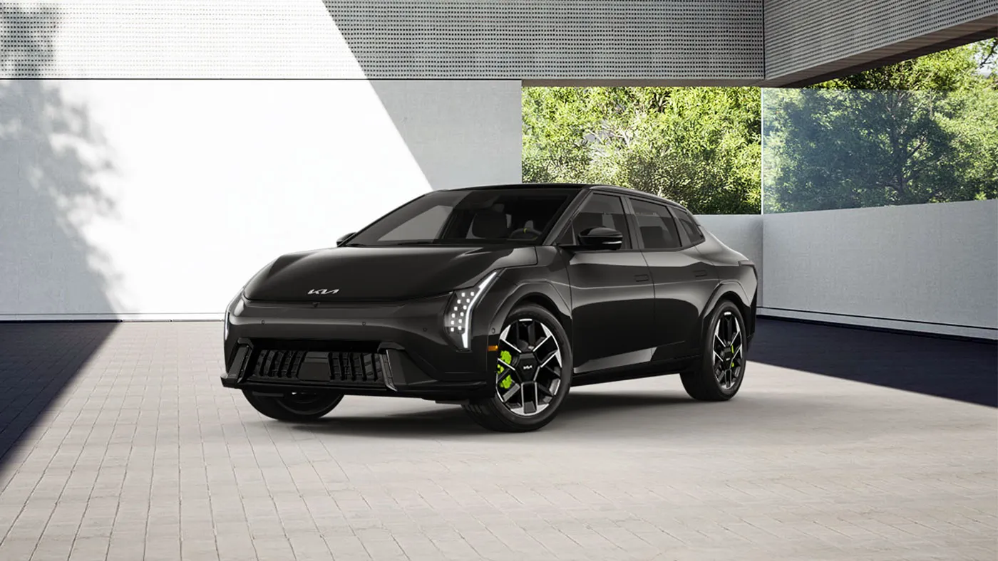 Kia EV4 GT 2027 grise vue de trois quarts avant, avec ses jantes sportives et ses &eacute;triers vert fluo.