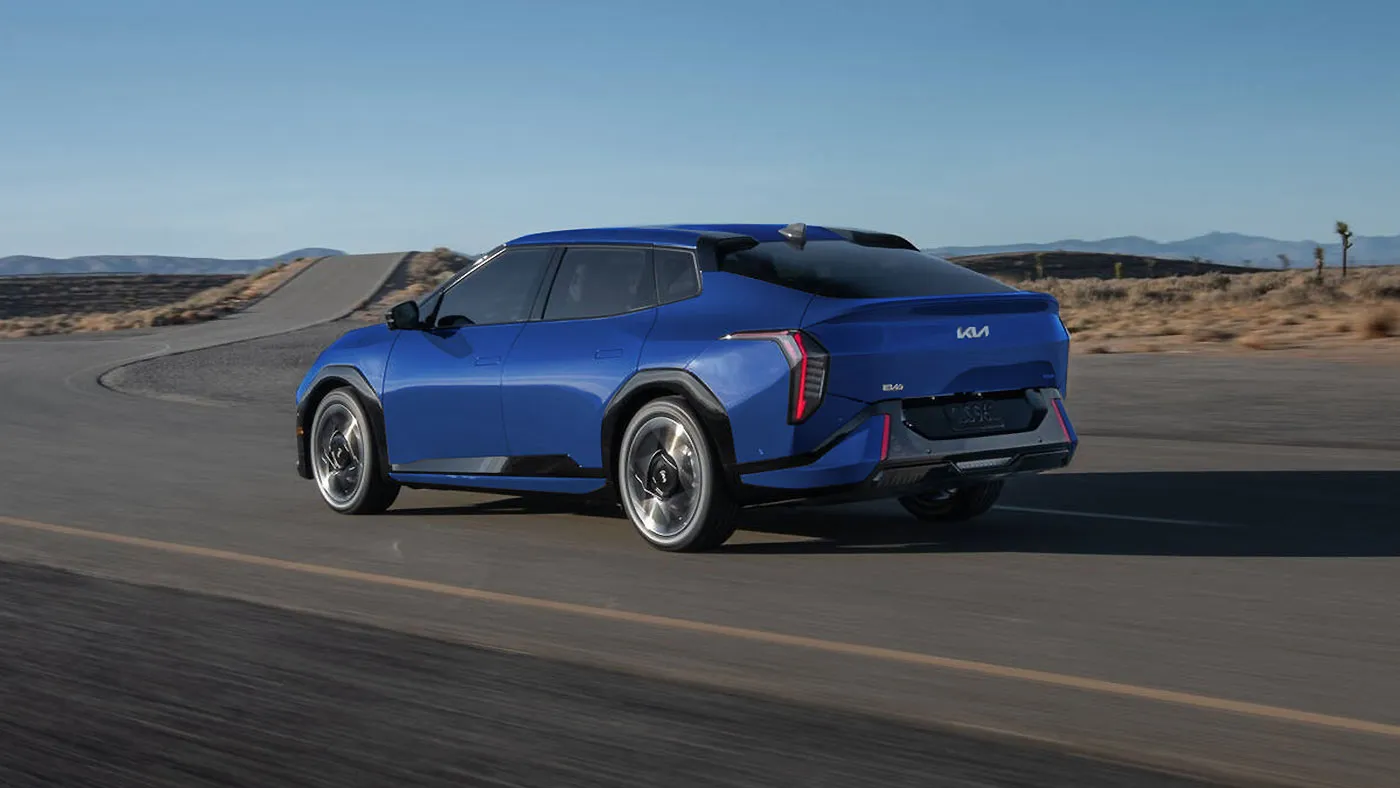 Kia EV4 &eacute;lectrique bleue vue de trois quarts arri&egrave;re sur la route, illustrant le guide d&rsquo;achat au Qu&eacute;bec.