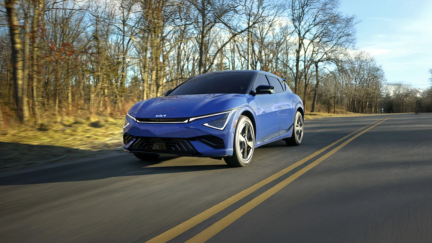 Vue 3/4 avant et lat&eacute;rale du Kia EV6 2025sur route en pleine puissance