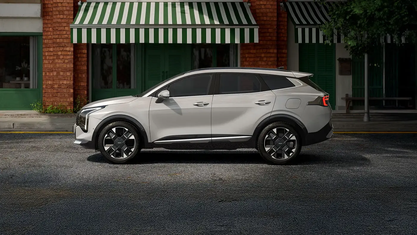 Kia Sportage 2026 gris vu de profil, stationn&eacute; devant des commerces.