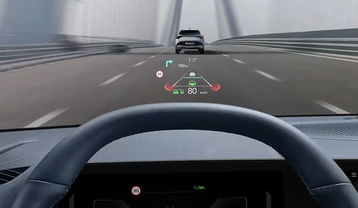 Affichage t&ecirc;te haute du Kia Sportage PHEV indiquant la vitesse et les aides &agrave; la conduite sur un pont.
