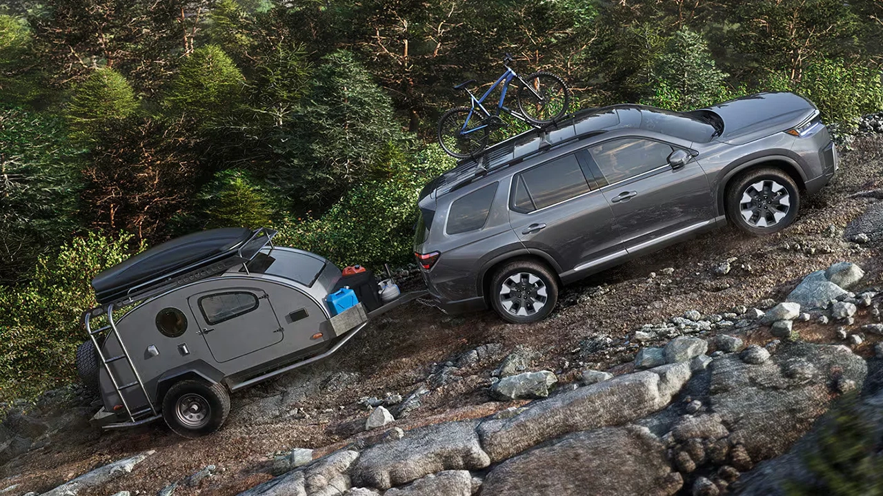 Vue lat&eacute;rale du Honda Pilot 2026 tirant une roulotte