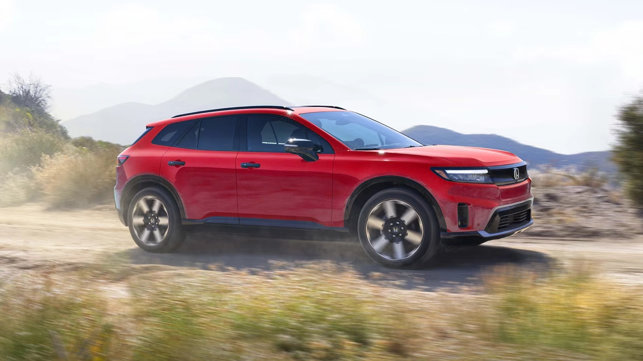 Vue 3/4 avant et lat&eacute;rale du Honda Prologue 2026 en pleine puissance sur route de sable