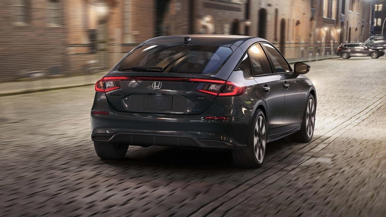 Vue arri&egrave;re d'un Honda Civic Hybrid 2026 sur rue pav&eacute;