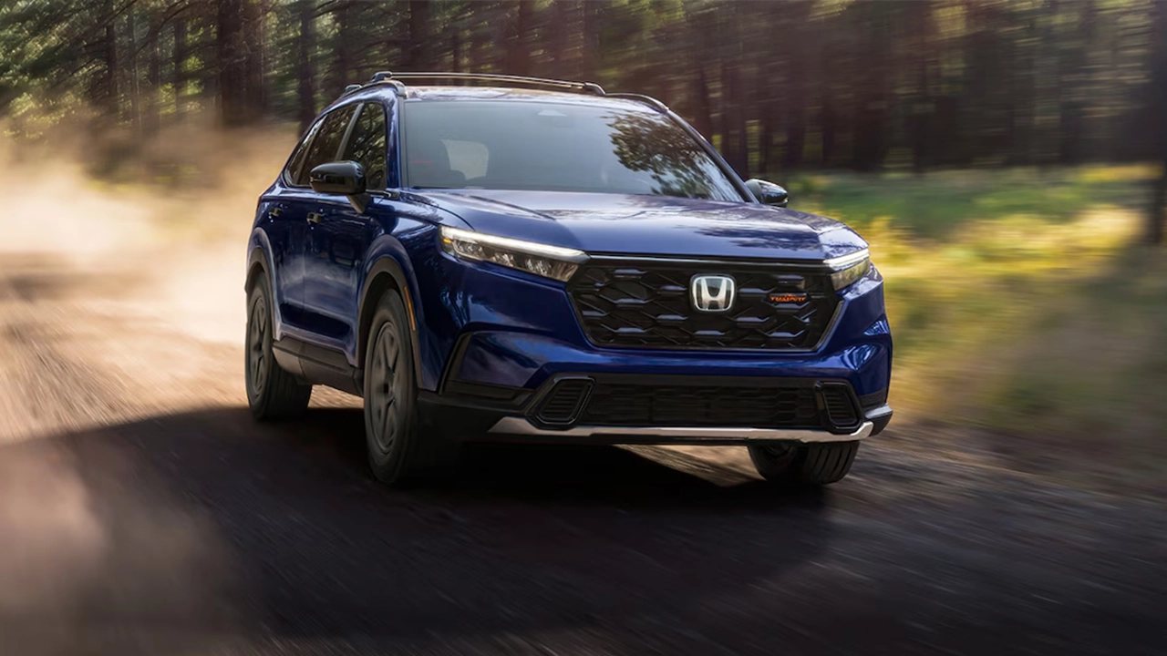 Vue 3/4 avant et latérale de l'honda CRV 2026 sur route de terre en pleine puissance