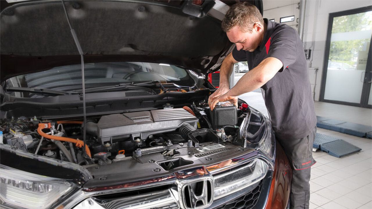 Gros plan sur les composants mécaniques d'un moteur Honda lors d'un entretien de routine