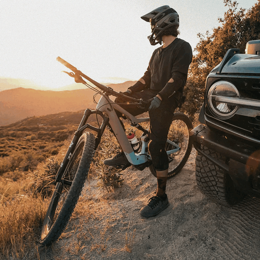 Mountain cyclist next to a Ford Bronco.
