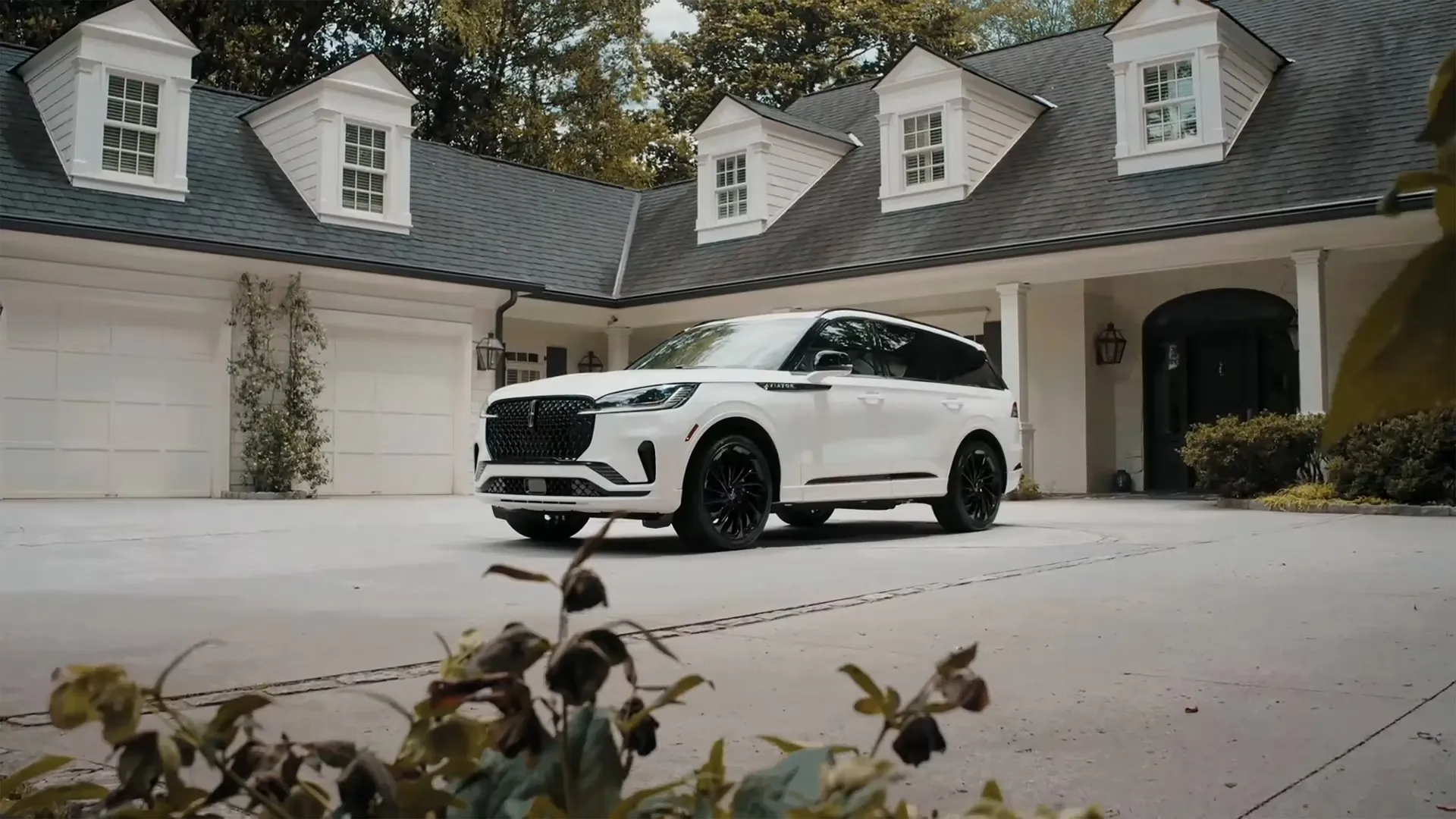 White Lincoln Aviator parked in front of a residence.