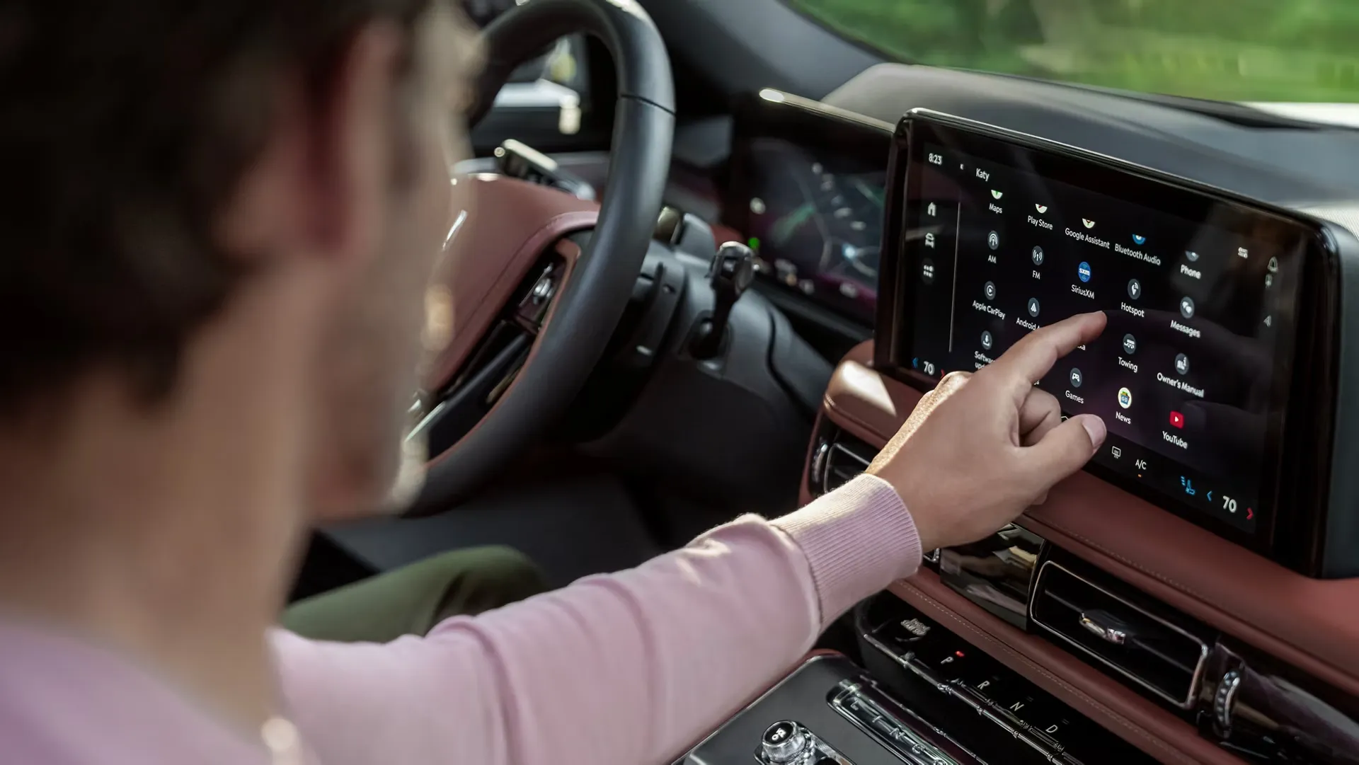 Driver using the touch screen of the Lincoln Aviator.