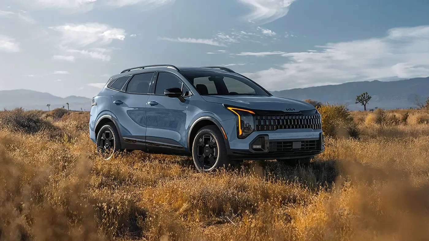 Kia Sportage 2026 bleu dans un paysage naturel.