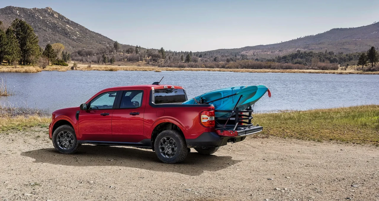 2026 Ford Maverick carrying kayaks near a lake.