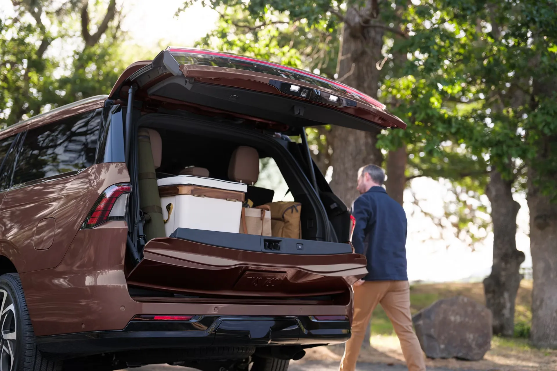 Chargement de bagages dans le Lincoln Navigator 2027 avec hayon divis&eacute;.