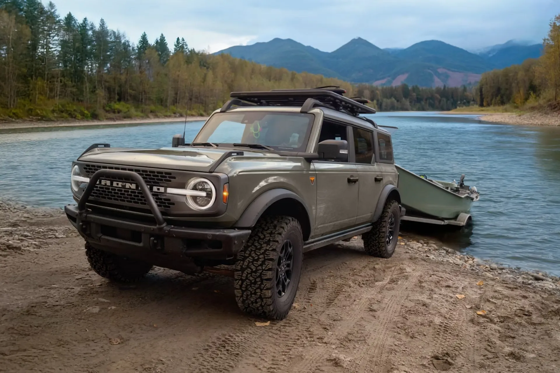 2026 Ford Bronco towing a watercraft near a lake.