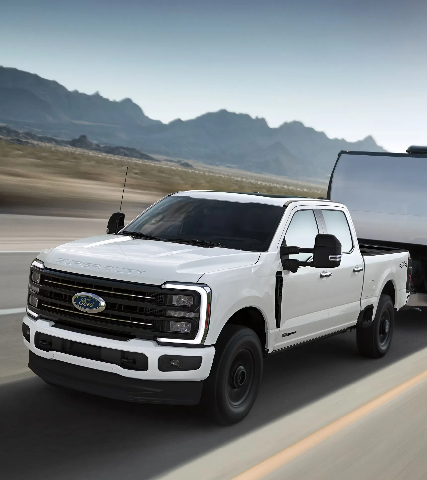 White 2026 Ford F-350 Super Duty towing an enclosed trailer.