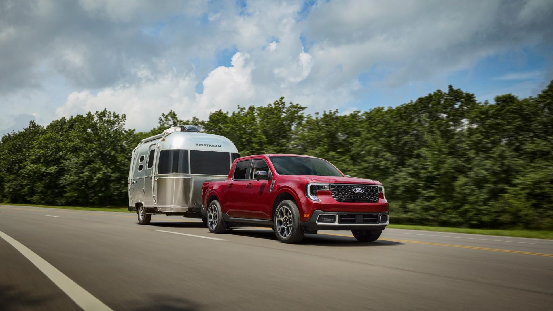 Red 2026 Ford Maverick towing a silver travel trailer.