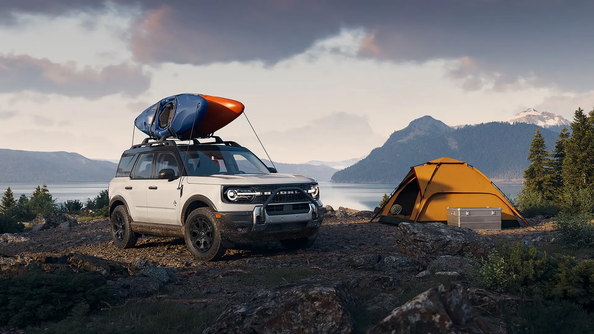 2026 Ford Bronco Sport equipped with kayaks near a tent by a lake.