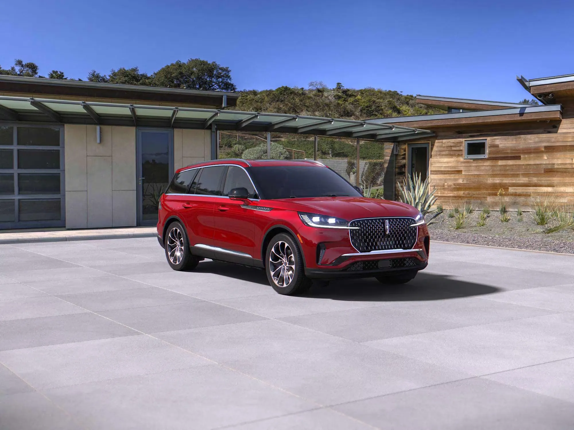 Red 2026 Lincoln Aviator parked in front of a modern residence.