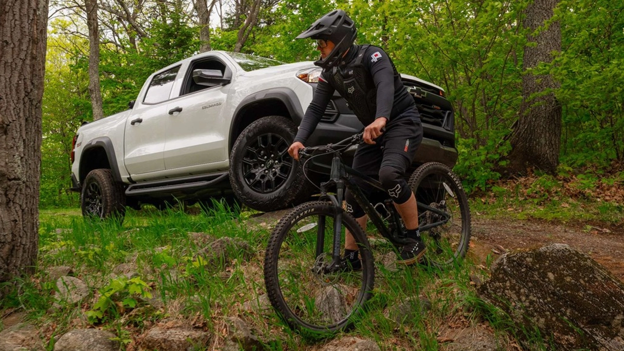Chevrolet Colorado blanc en for&ecirc;t,il a livr&eacute; le rider, maintenant il attend  pendant que lui s'amuse.