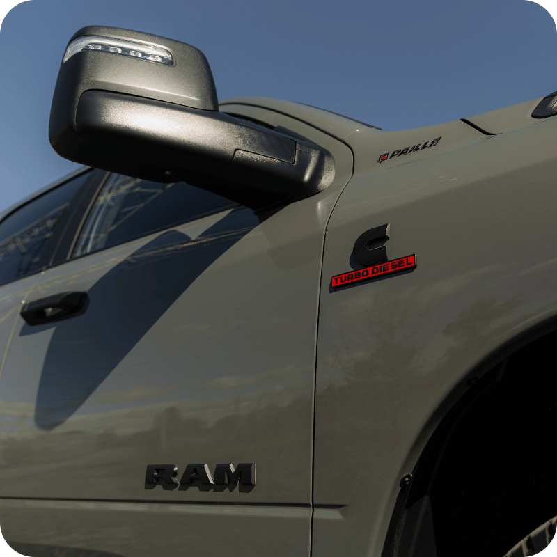 Gros plan sur le côté d’un RAM 2500 Turbo Diesel avec rétroviseur de remorquage et emblème Cummins.