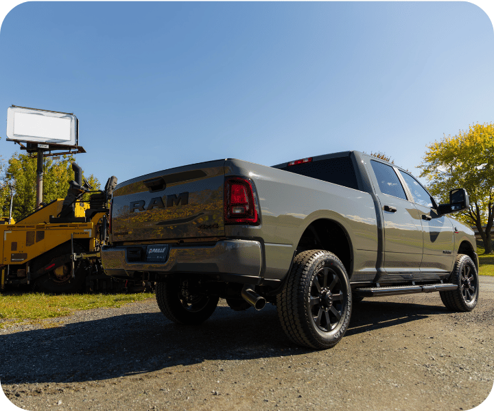 Rear view of the 2026 RAM 2500 parked on the side of the road with equipment