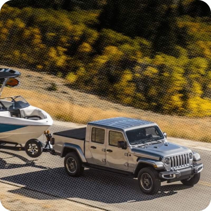Vue avant du Jeep Gladiator 2026 sur route tirant un bateau