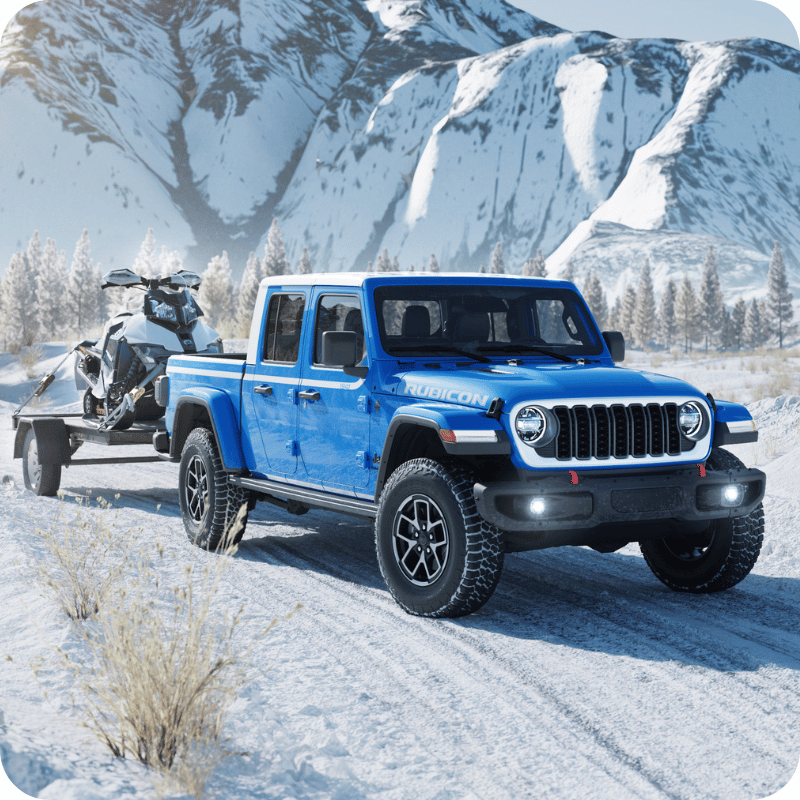 Blue Gladiator Rubicon towing a snowmobile.