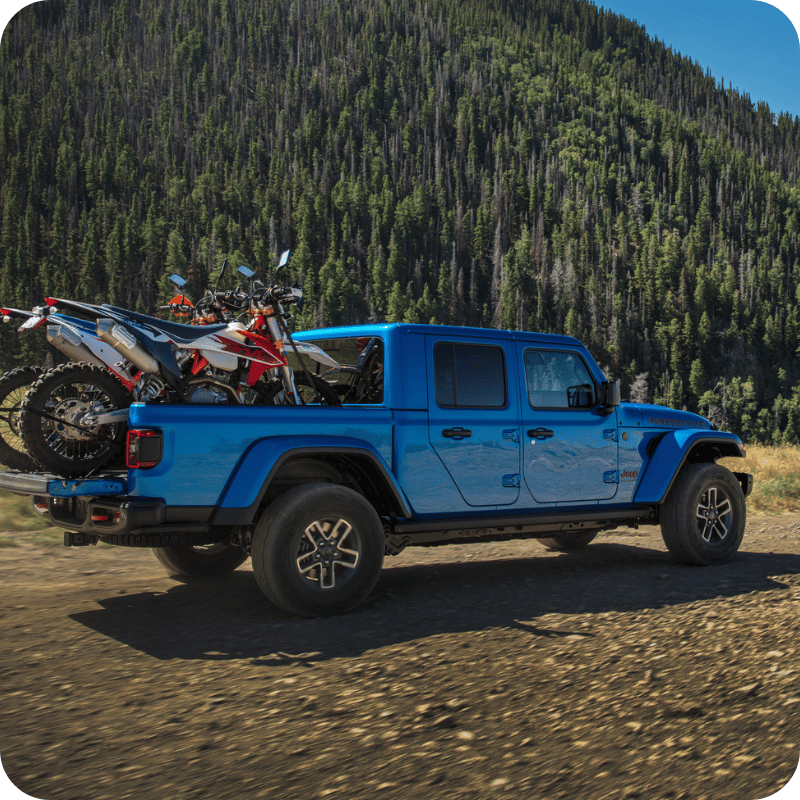 Blue Gladiator loaded with dirt bikes.