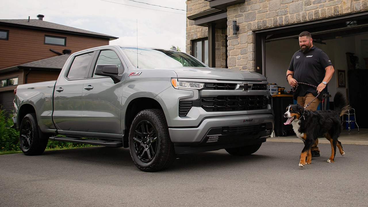 Homme et son chien pr&egrave;s d'un camion pickup noir