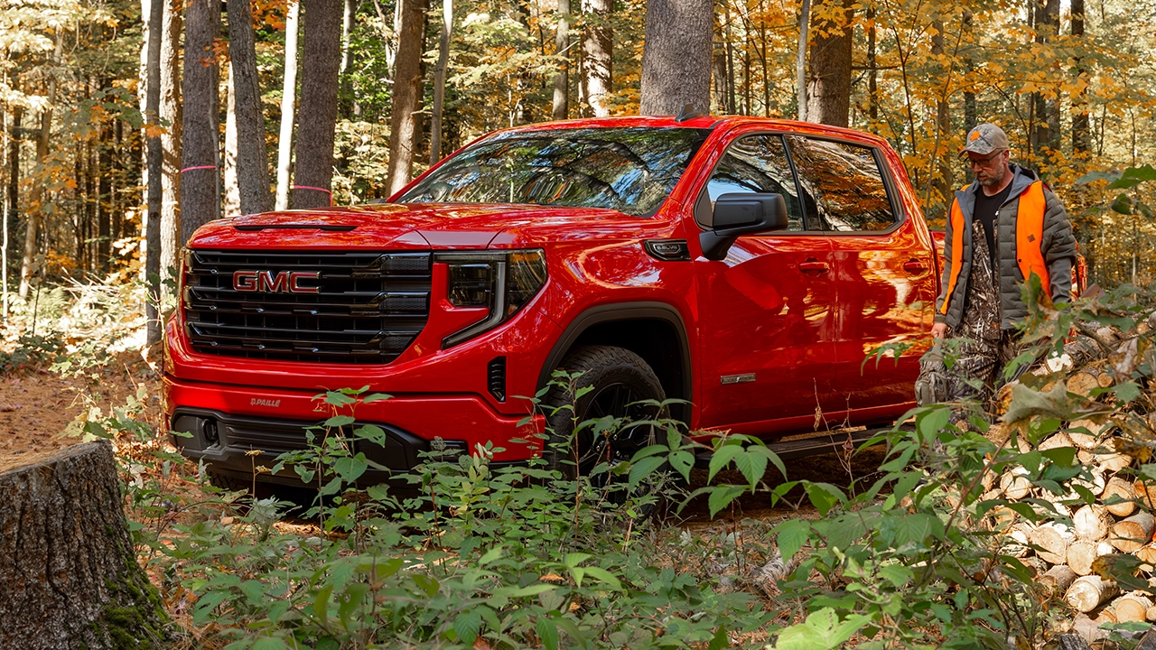 Camion GMC Sierra rouge en for&ecirc;t automnale