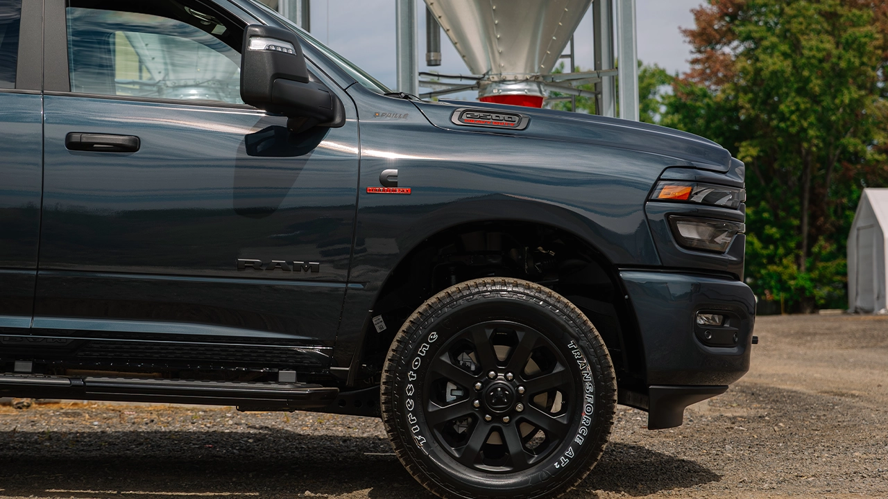 Camion RAM 2500 gris ardoise de profil sur terrain de gravier