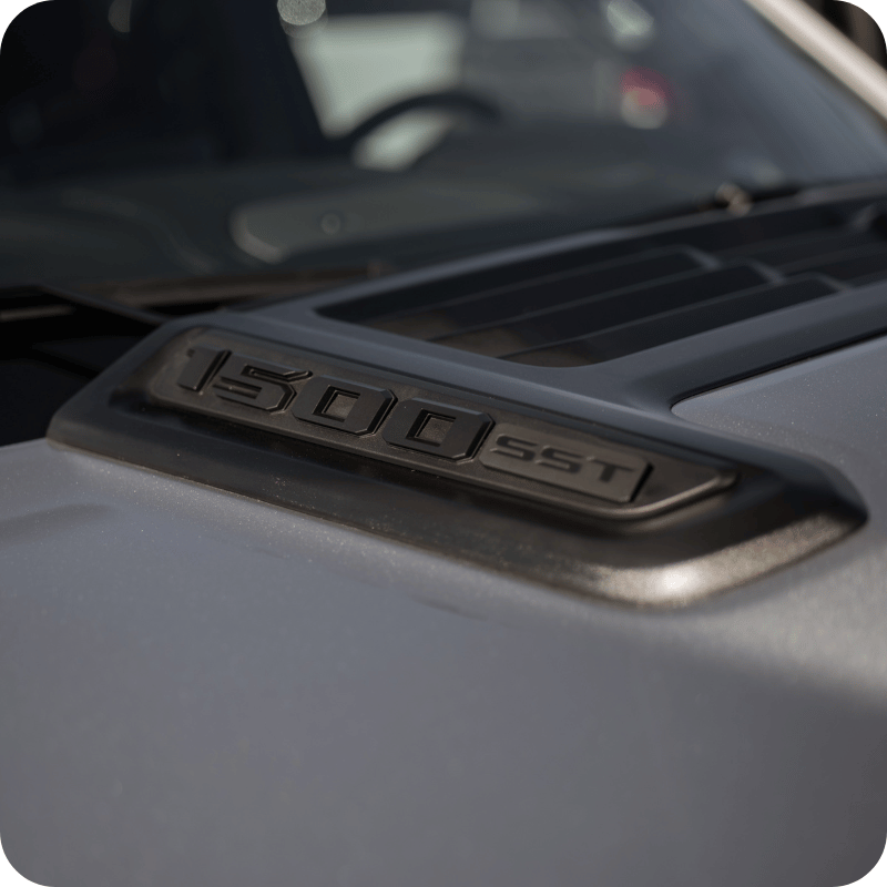 Gros plan sur l'emblème « 1500 SST » sur le capot d'un pick-up Ram gris.