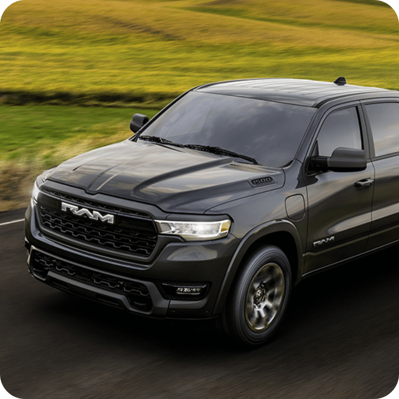 Gray Ram 1500 REV driving through countryside.