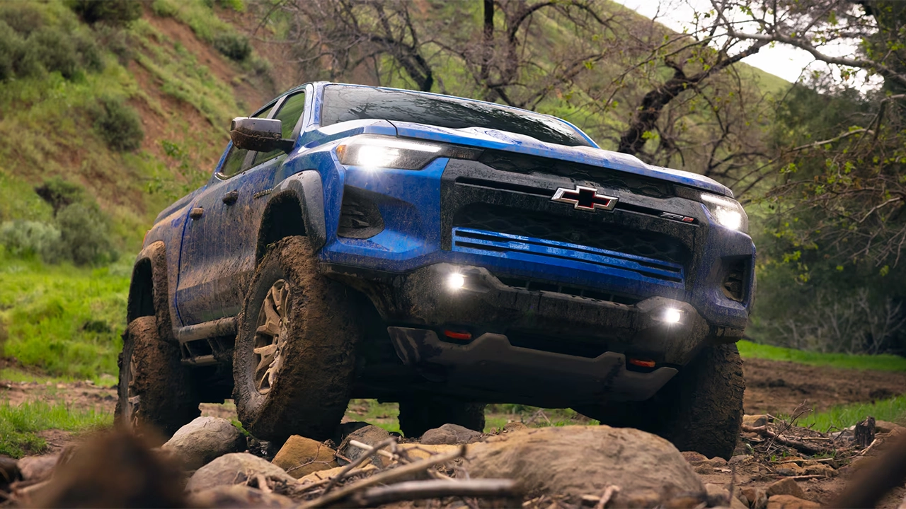 The 2026 Chevrolet Colorado driving on a rocky forest road.