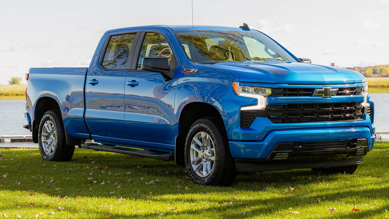 Vue 3/4 avant et latérale du Chevrolet Silverado 1500 2026 en bord de l'eau ayant remorquer un bateau