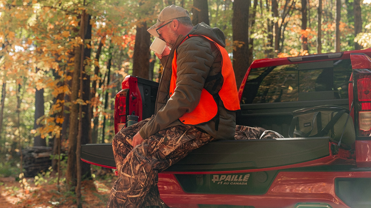Vue arrière du Chevrolet Silverado 1500 2026 avec le panneau ouvert et le chasseur prenant un café matinal