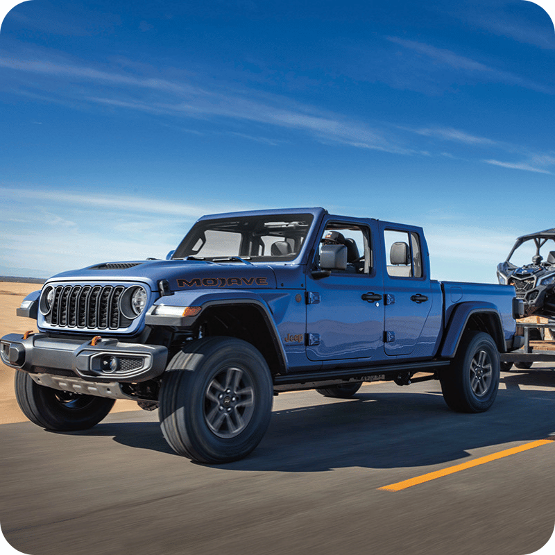 Vue avant et latérale du Jeep Gladiator 2026 sur route tirant une remorque avec un VTT