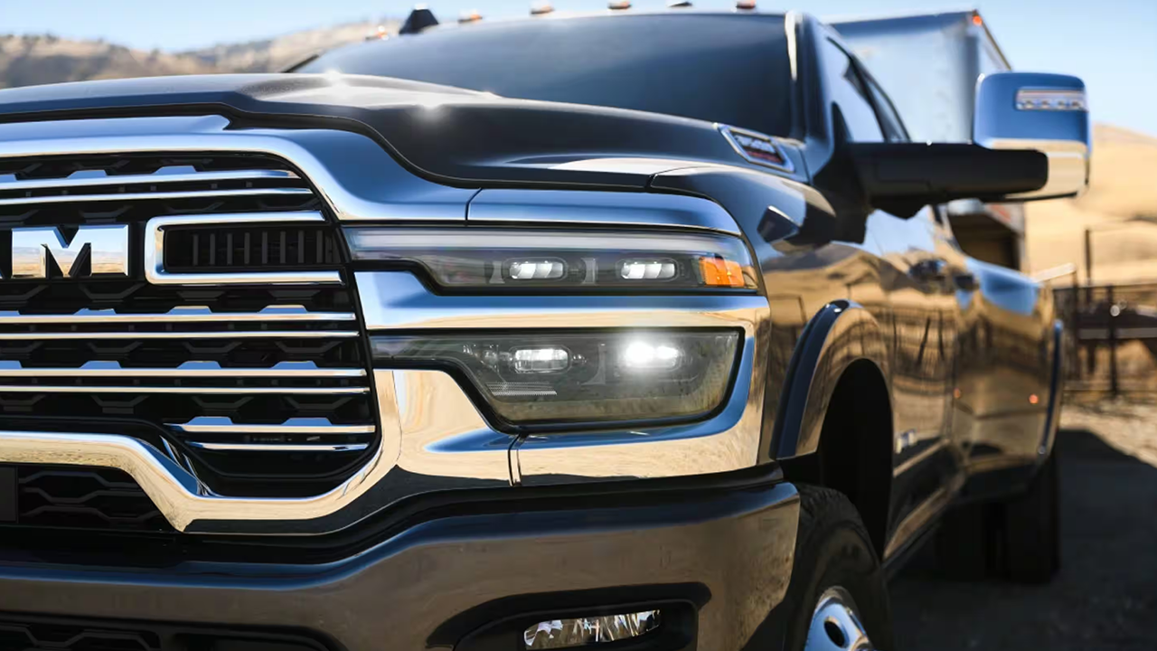 Le rétroviseur extérieur côté conducteur, le phare et une partie de la calandre d'un camion poids lourd Ram 3500 Limited Longhorn 2026 de couleur noire.